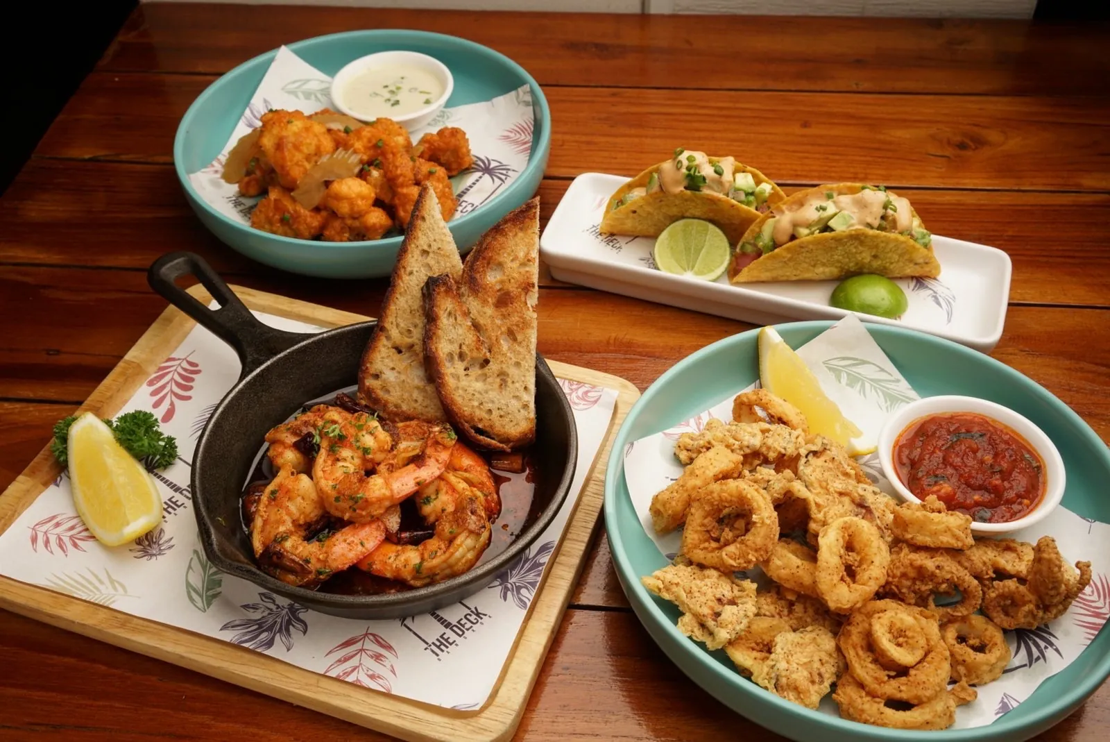 Sharing plates at The Deck: garlic prawns, calamari, tacos and buffalo cauliflower